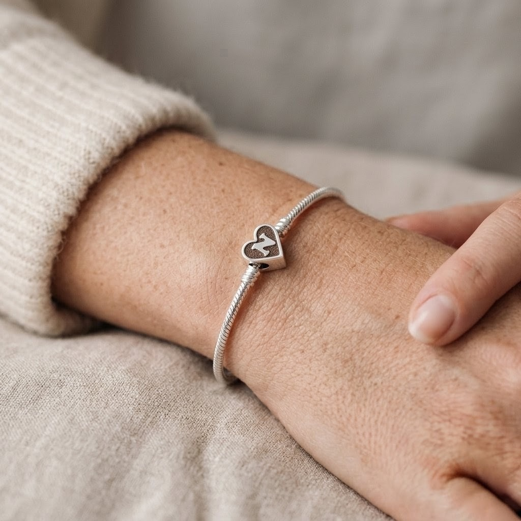 Cuenta corazón con inicial para pulsera de cenizas puesta en la muñeca, joyería memorial artesanal